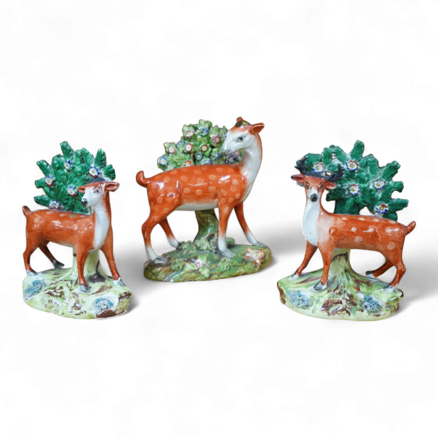 Three early 19th century Staffordshire pottery models of deer, largest 16cm high